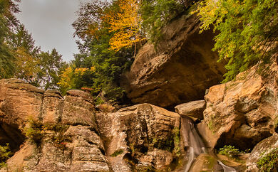 A cropping of a large rock face peeks out from among a forrest.